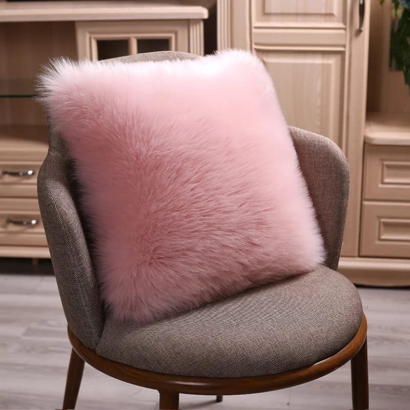 A pink pillow on a wooden chair in front of another chair.