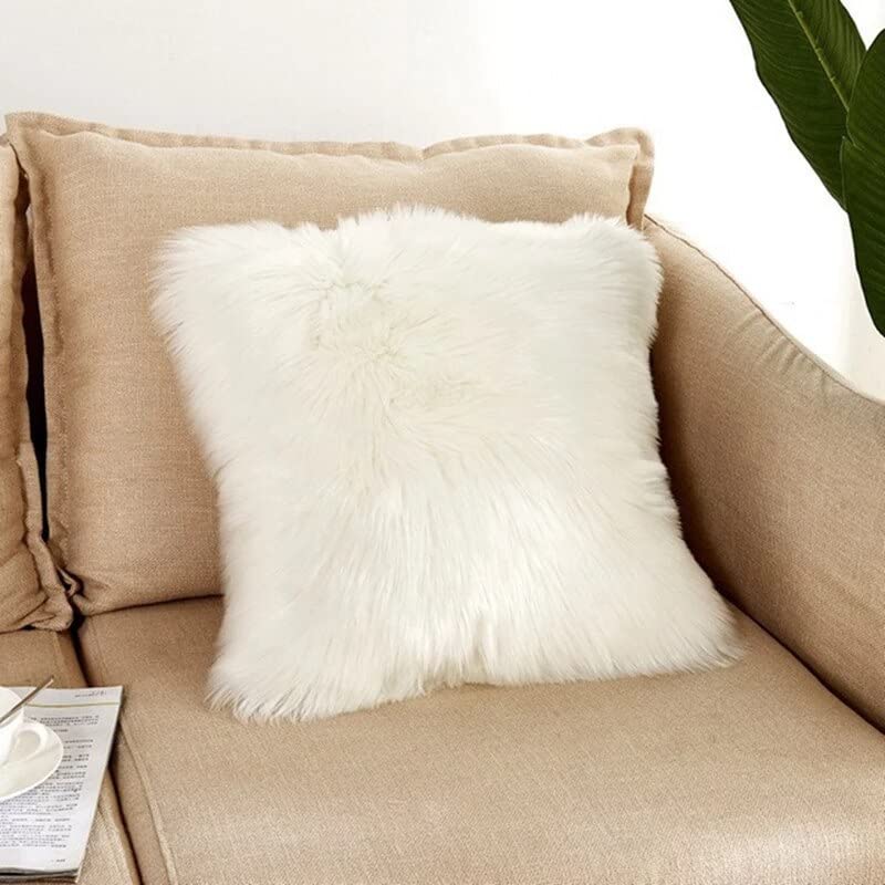 A cozy couch with a white pillow and a lovely plant. Perfect for relaxing and adding a touch of nature to your living space.