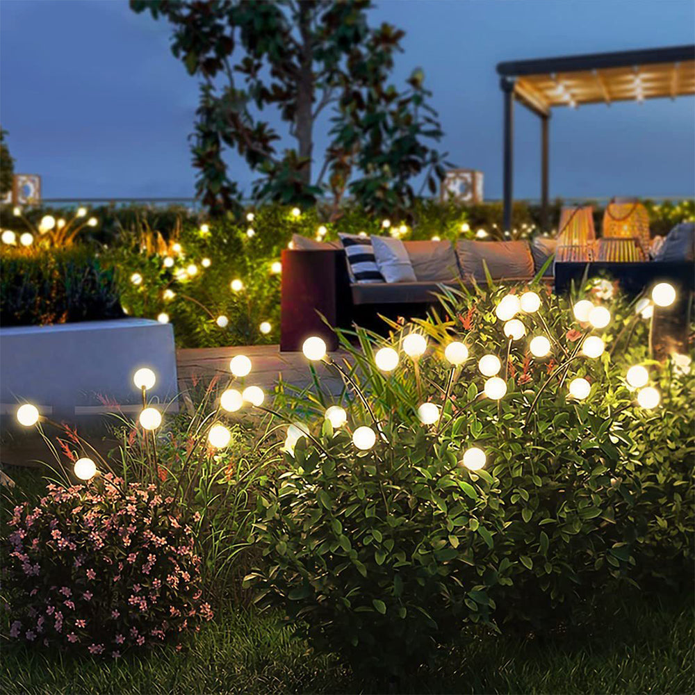 A cluster of garden lights illuminating a dark night, creating a warm and inviting atmosphere.