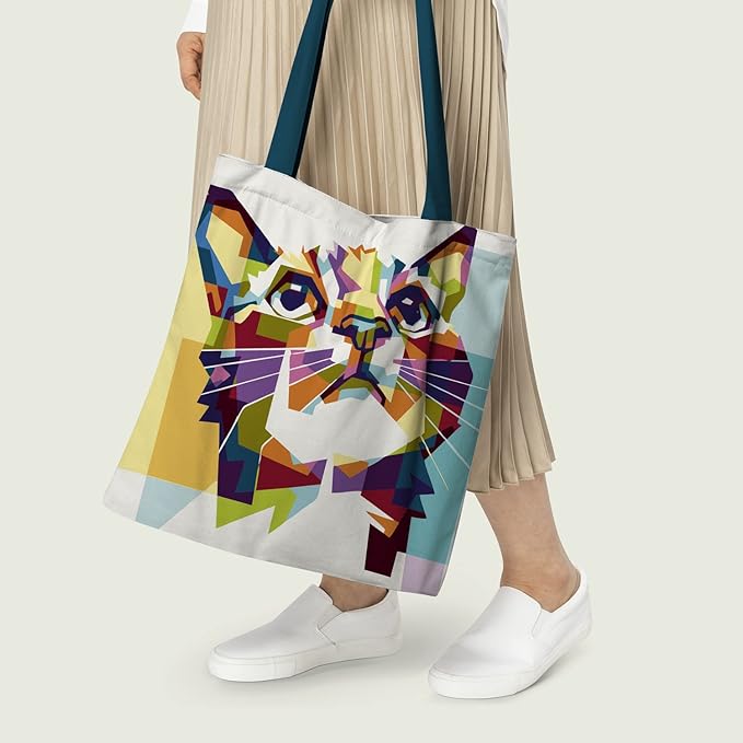 Women holding A vibrant tote bag featuring a cat face design in various colors.