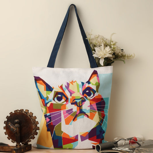 A vibrant tote bag featuring a cat face design, filled with colorful patterns and eye-catching details.