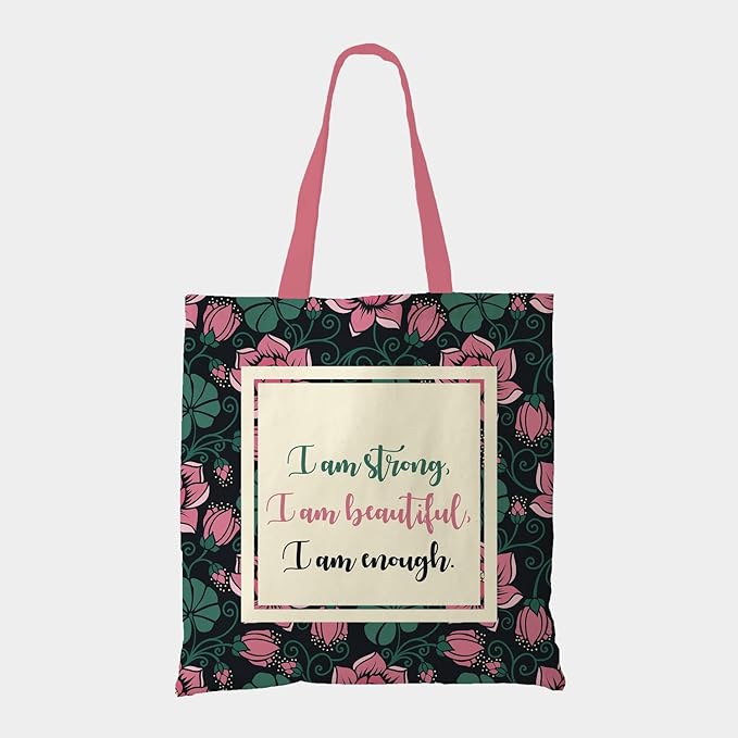 Black tote bag with a quote: ""I am strong, I am beautiful, I am strong"" surrounded by green and pick florals with pink color matching handleTote bag featuring the empowering quote "I am strong, I am beautiful, I am strong".