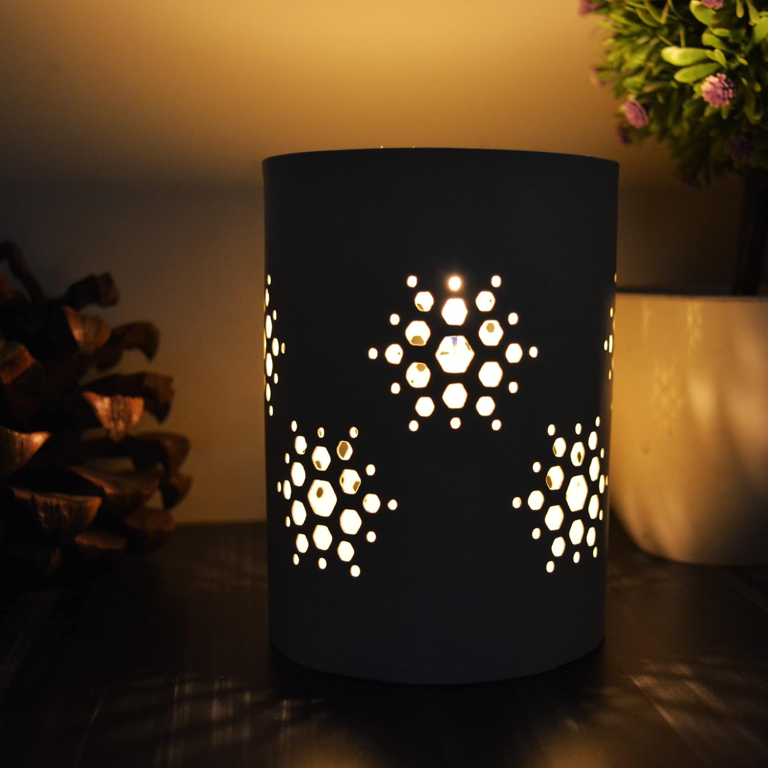 Elegant black candle holder featuring intricate cut-out designs, ideal for creating a cozy ambiance.