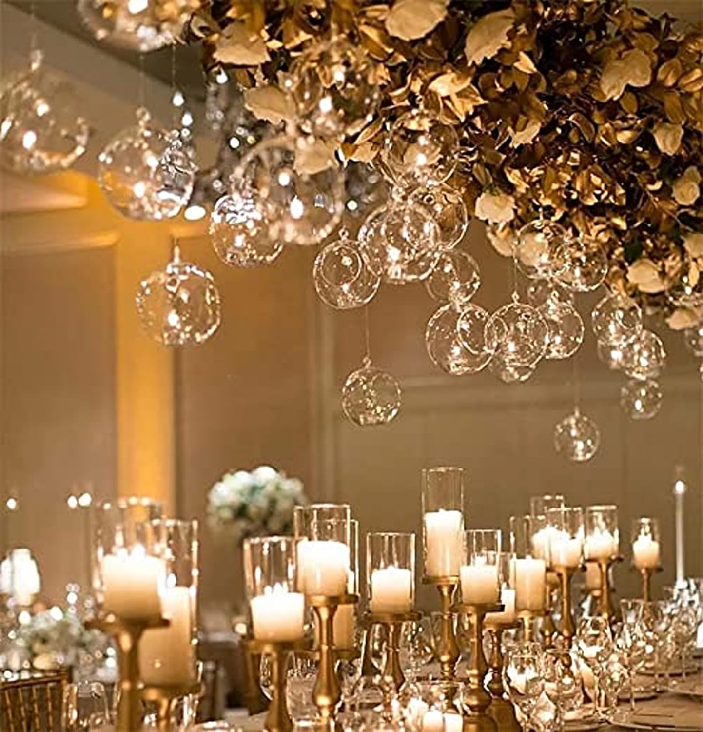 A wedding reception table with candles and glass vases.