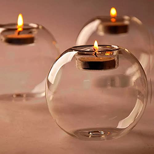 Three lit candles in glass tealight holders.