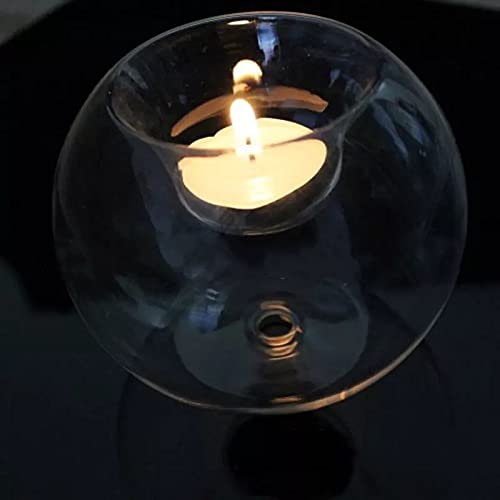 Three glass tealights with lit candles glowing inside.