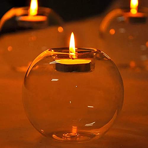 Three glass tealights with flickering candles inside, casting a warm and cozy glow.