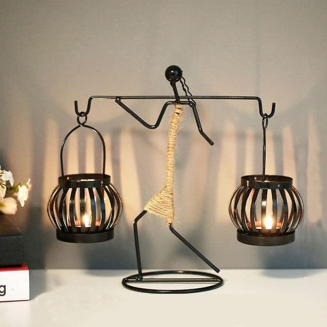  Metal sculpture featuring candle holder with lit candle.