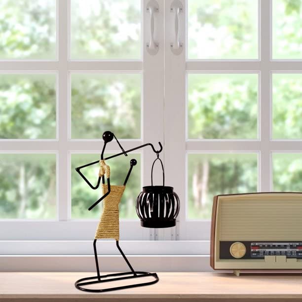 A radio and a statue of a woman on a table.