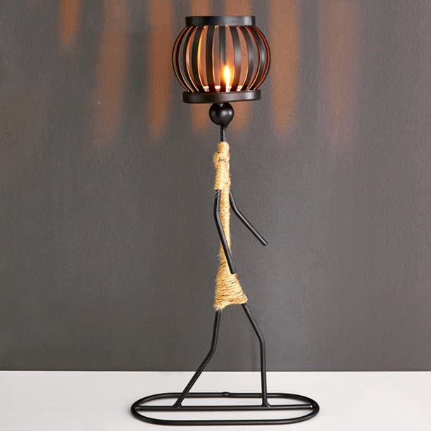 A metal candle holder with a lit candle on top.