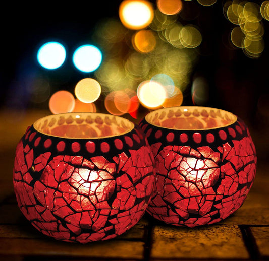 Two vibrant red glass tealights displayed on a table.