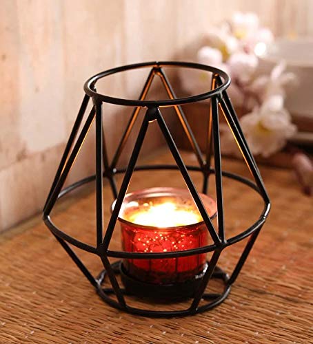 A black candle holder with a red candle burning brightly.