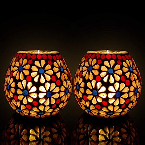 Colorful glass tealights set on black surface.