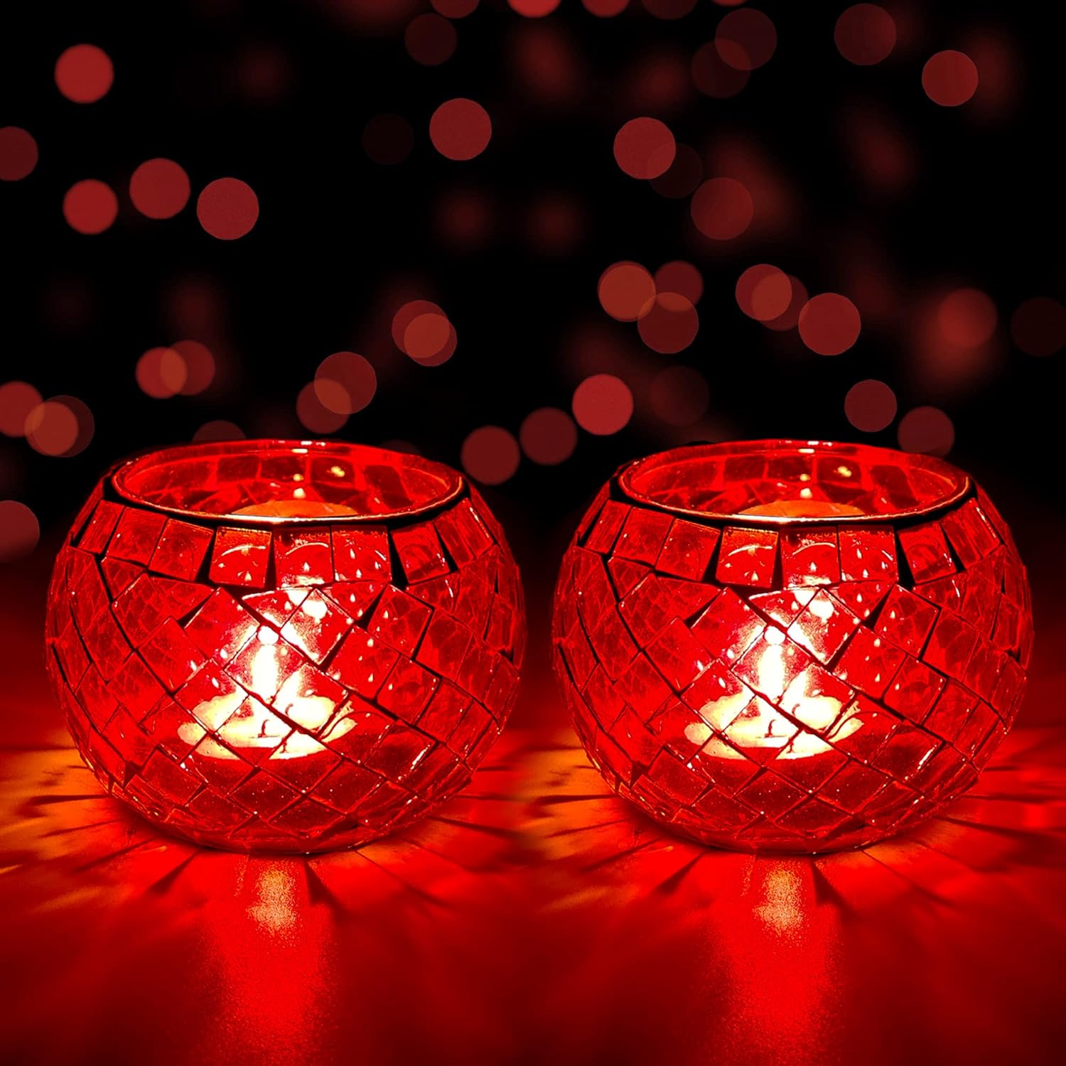 Two red glass tealights glowing on a table