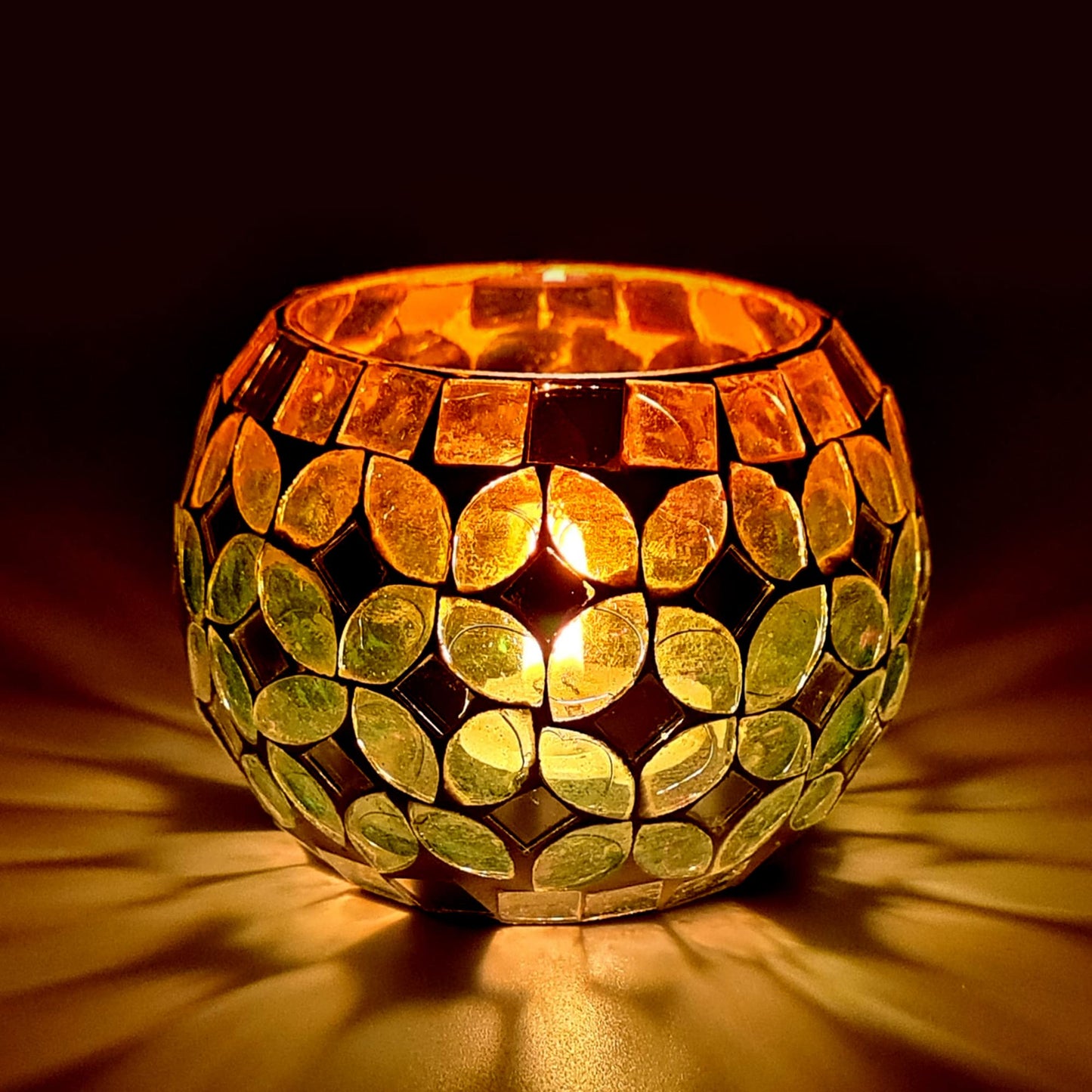 Two golden candles glowing brightly on a dark background.