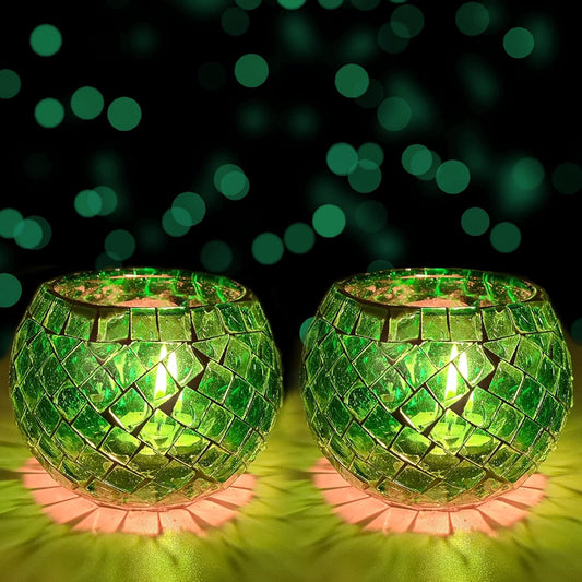 Two green glass tealights displayed on a table