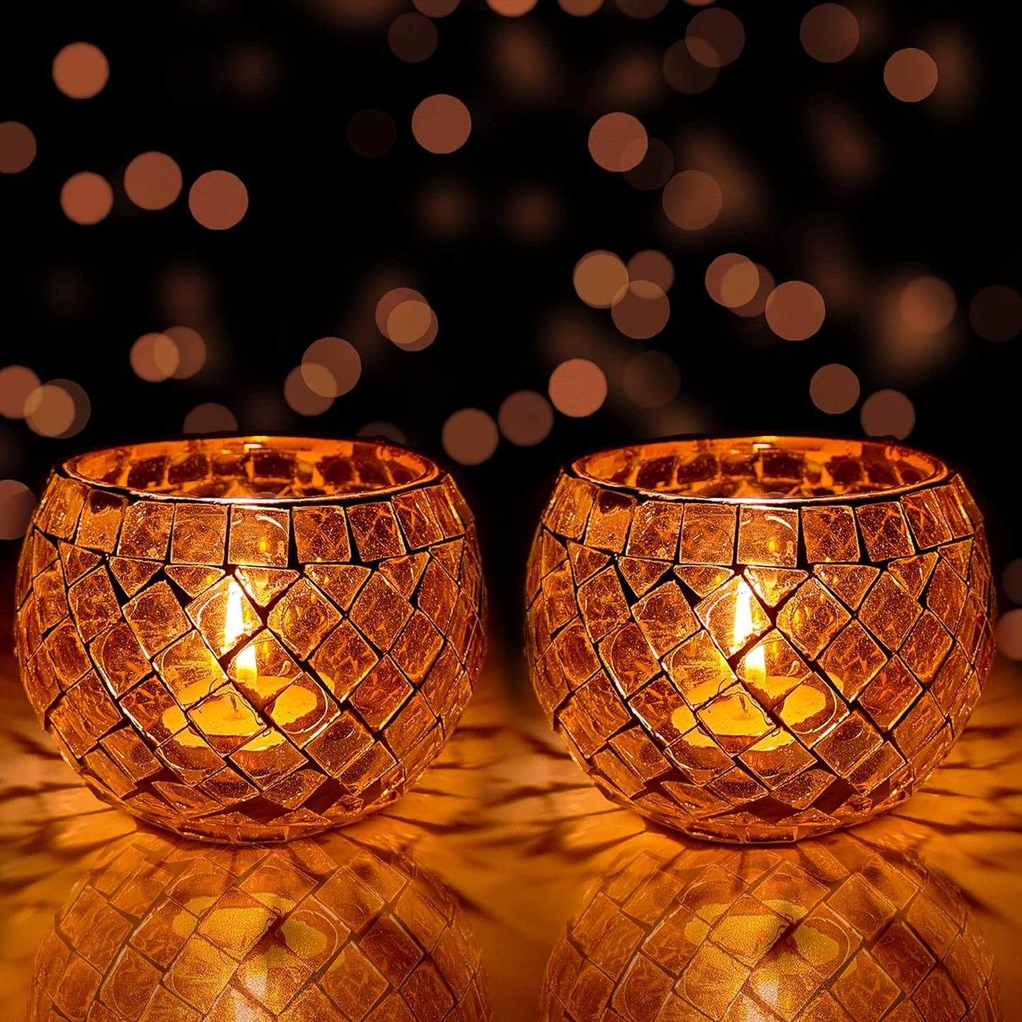  Pair of orange glass tealight holders with flickering candles inside.