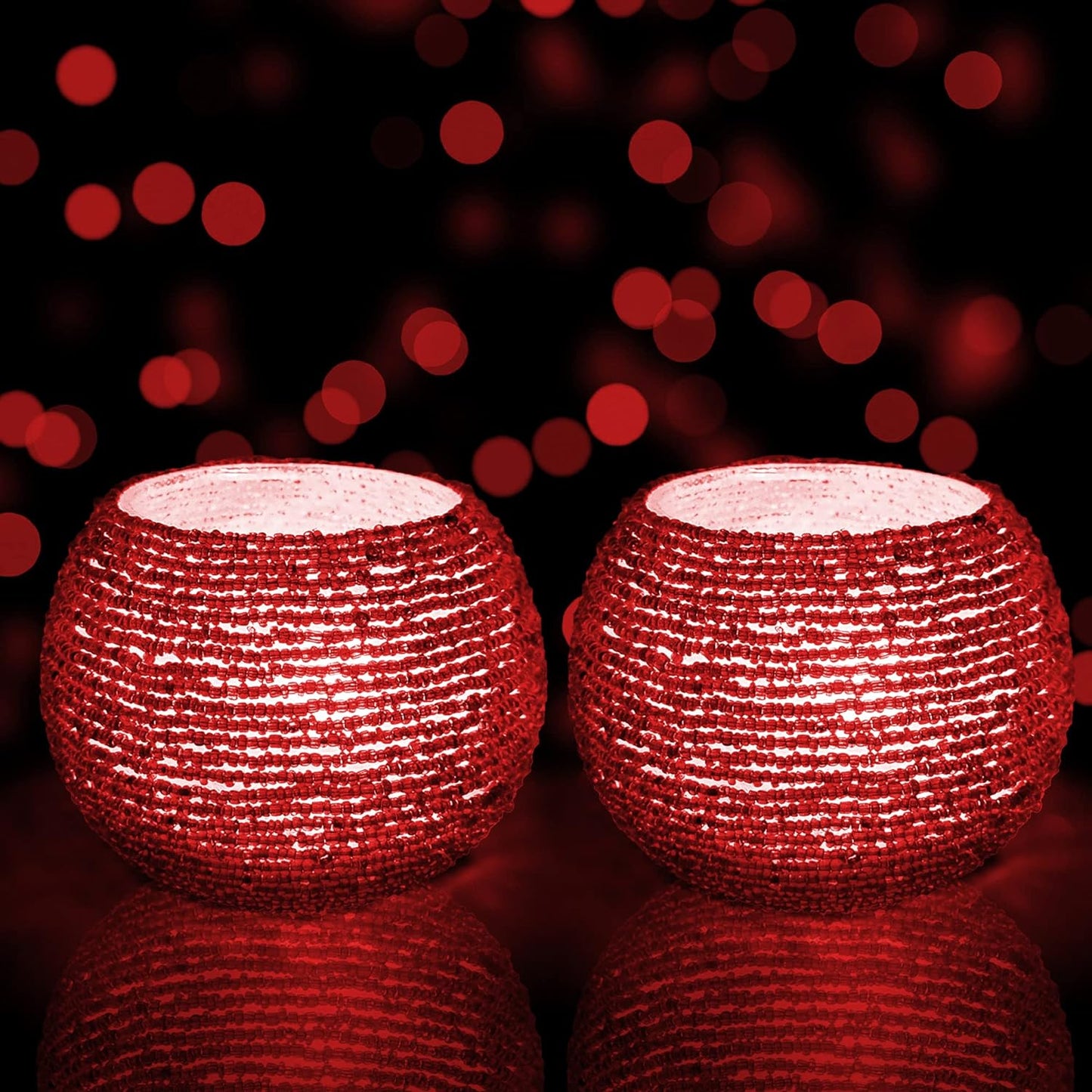 Two red candles glowing on black background.