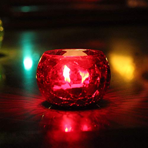 Red candle glowing in glass bowl.