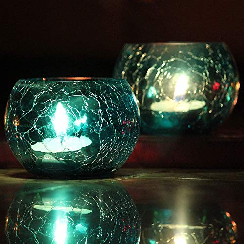 Glass tealight holders with candles glowing inside.