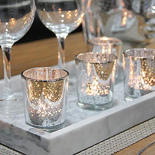 Display of four silver glass votives on tray.