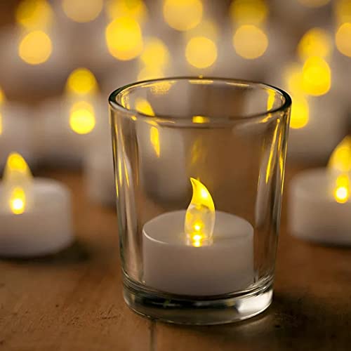  Wooden stand holding four glass votive candles, glowing softly.