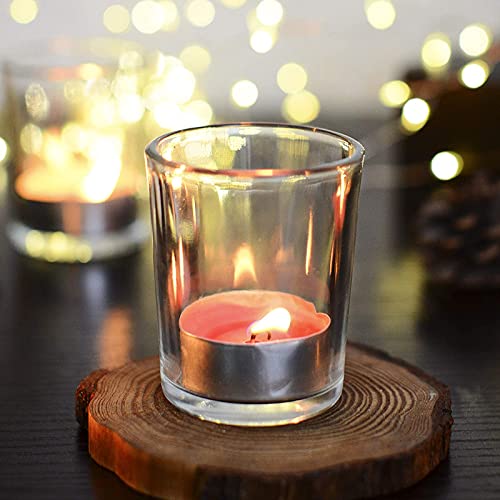 Group of four glass votive candles on rustic wooden stand.