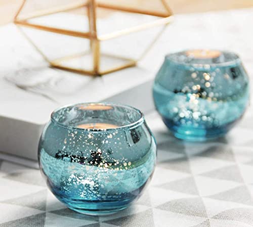 Two blue glass tealight holders on a table