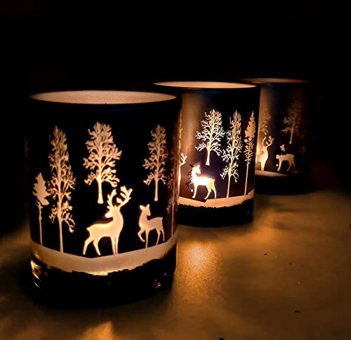 Two glass candles with deer and trees designs, perfect for adding a cozy touch to your home decor.