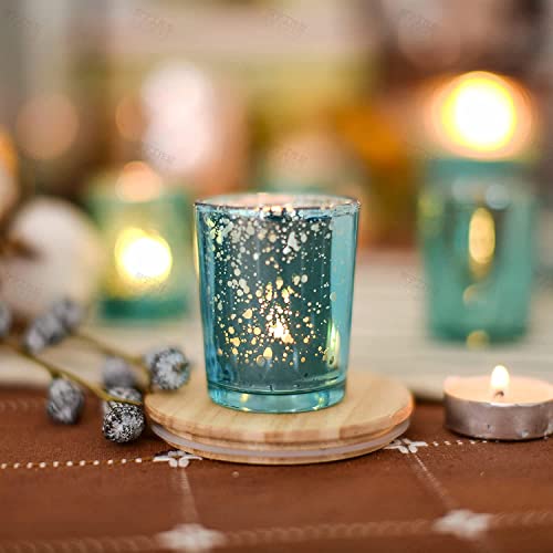 Teal glass candle holder with lit candles and a small plate