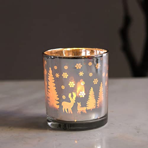 A glass candle holder with a deer and trees design.