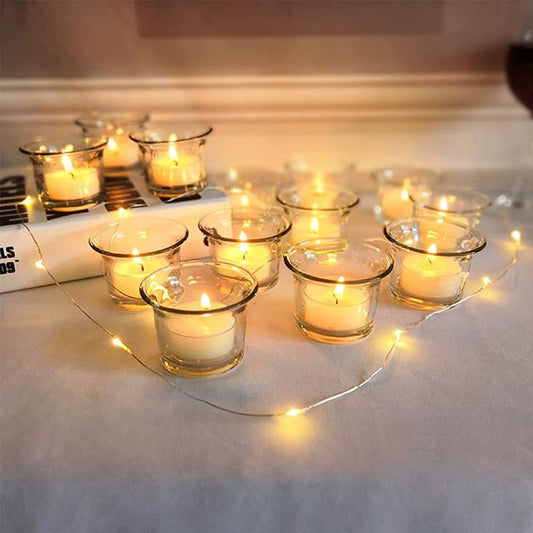  Votive Glass Tealight cups filled with glowing candles
