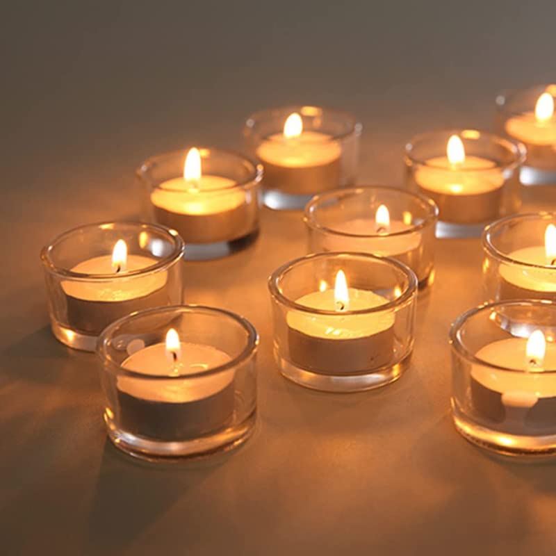 Several small candles in clear glass cups, creating a warm and cozy atmosphere.