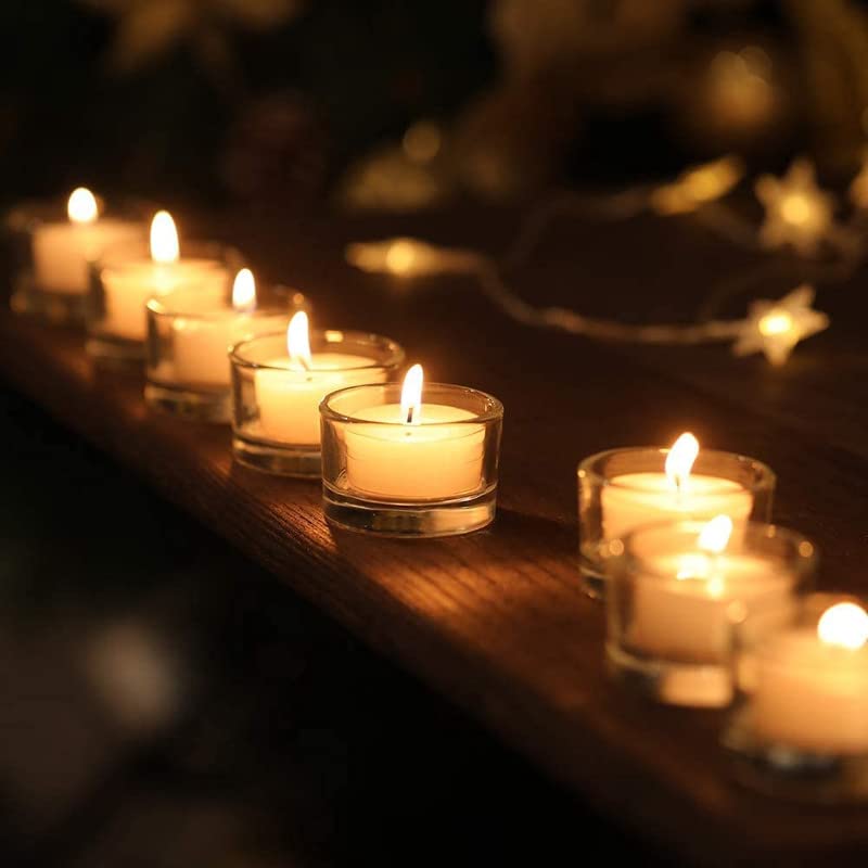 Array of small candles in transparent glass holders, emitting a soft glow.