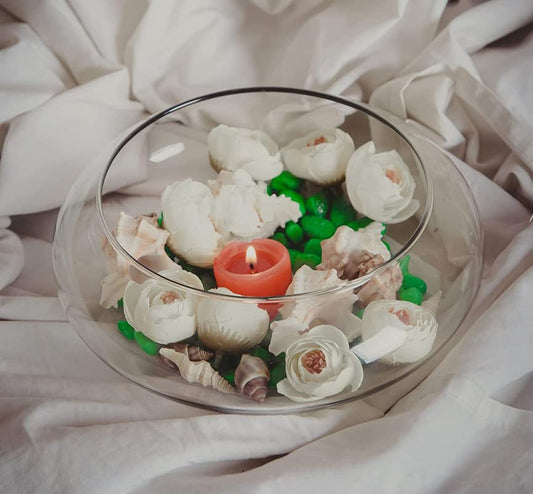  A bowl filled with seashells and candles, creating a serene beach-inspired centerpiece.