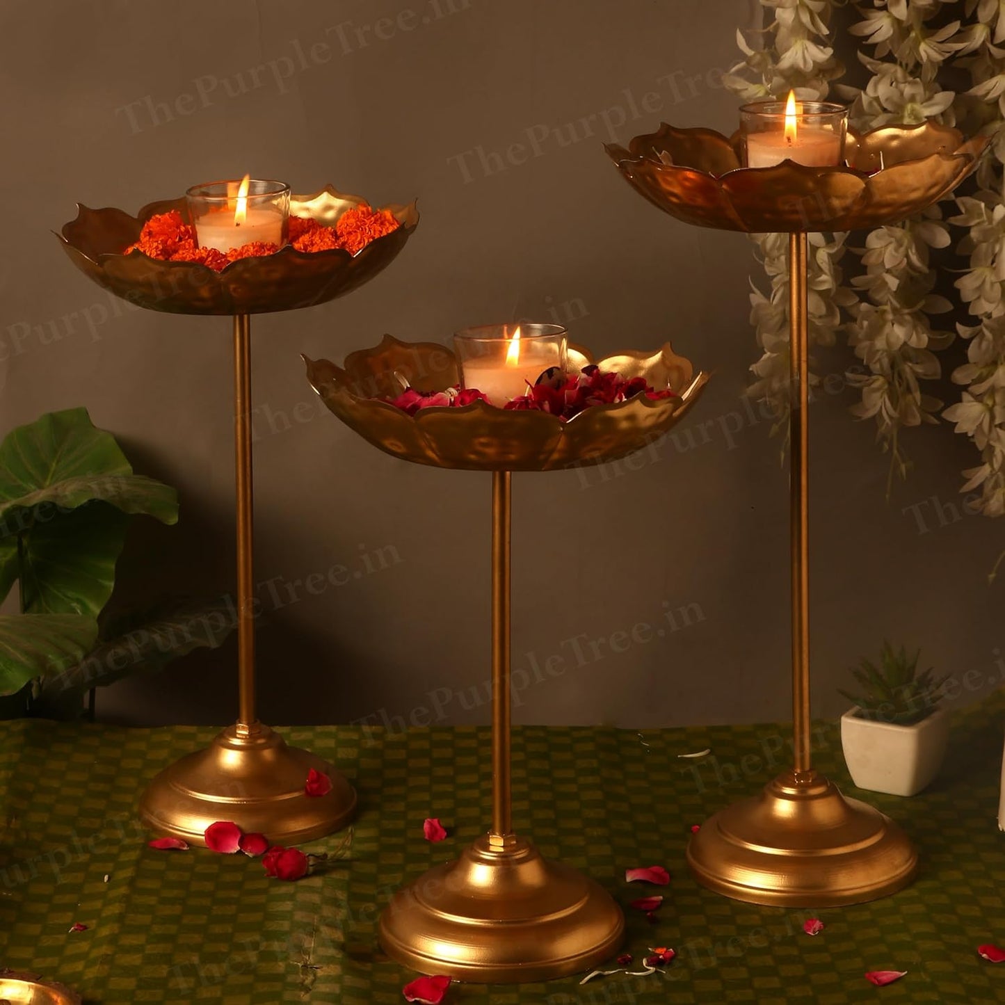 Three gold flower stands with beautiful flowers on top. A stunning display of nature's beauty and elegance.