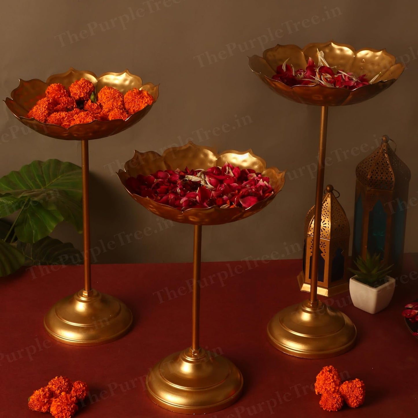 Trio of elegant gold flower stands adorned with vibrant flowers.