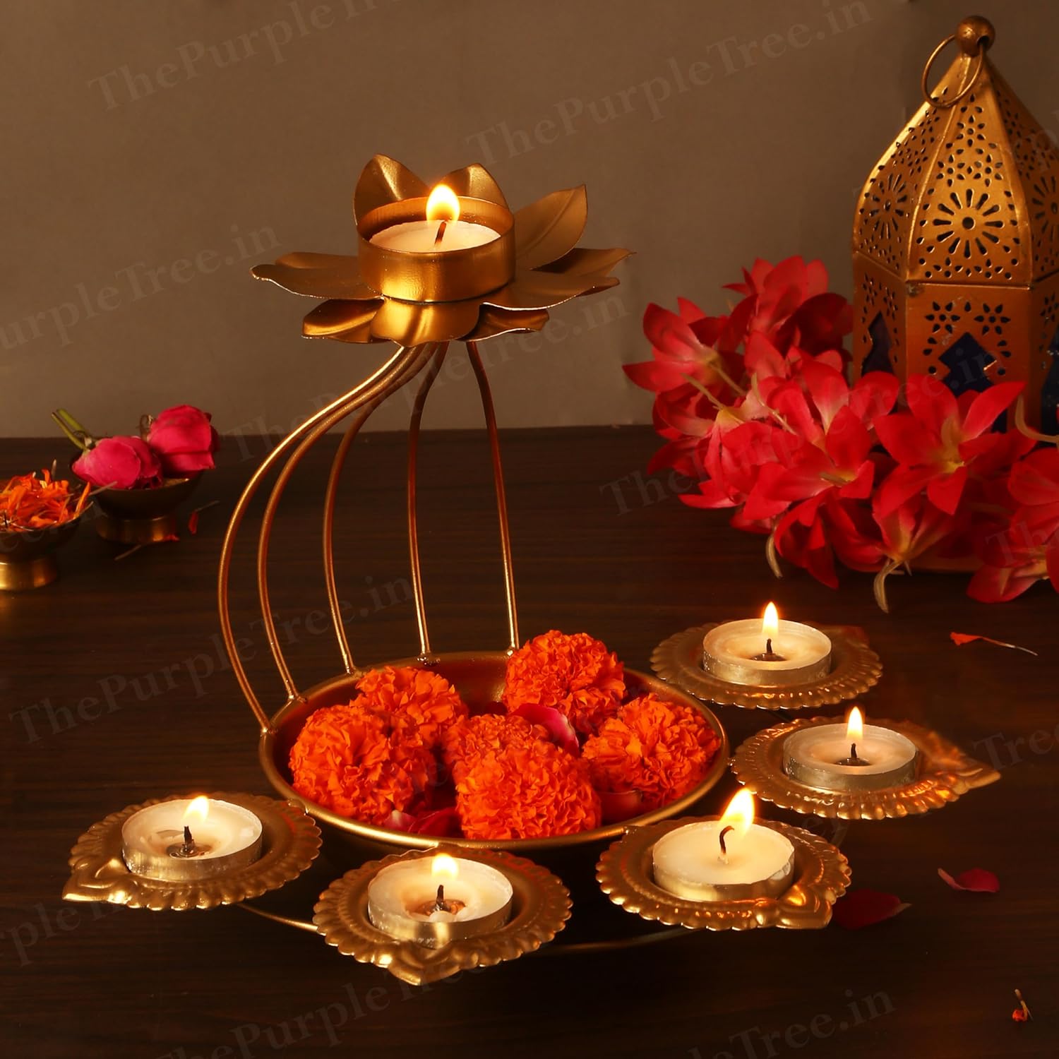 A decorative gold candle holder with flowers and lit candles placed on a table, creating an elegant ambiance.