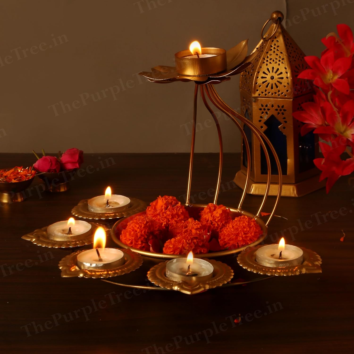  A table set with a gold candle holder, flowers, and candles.