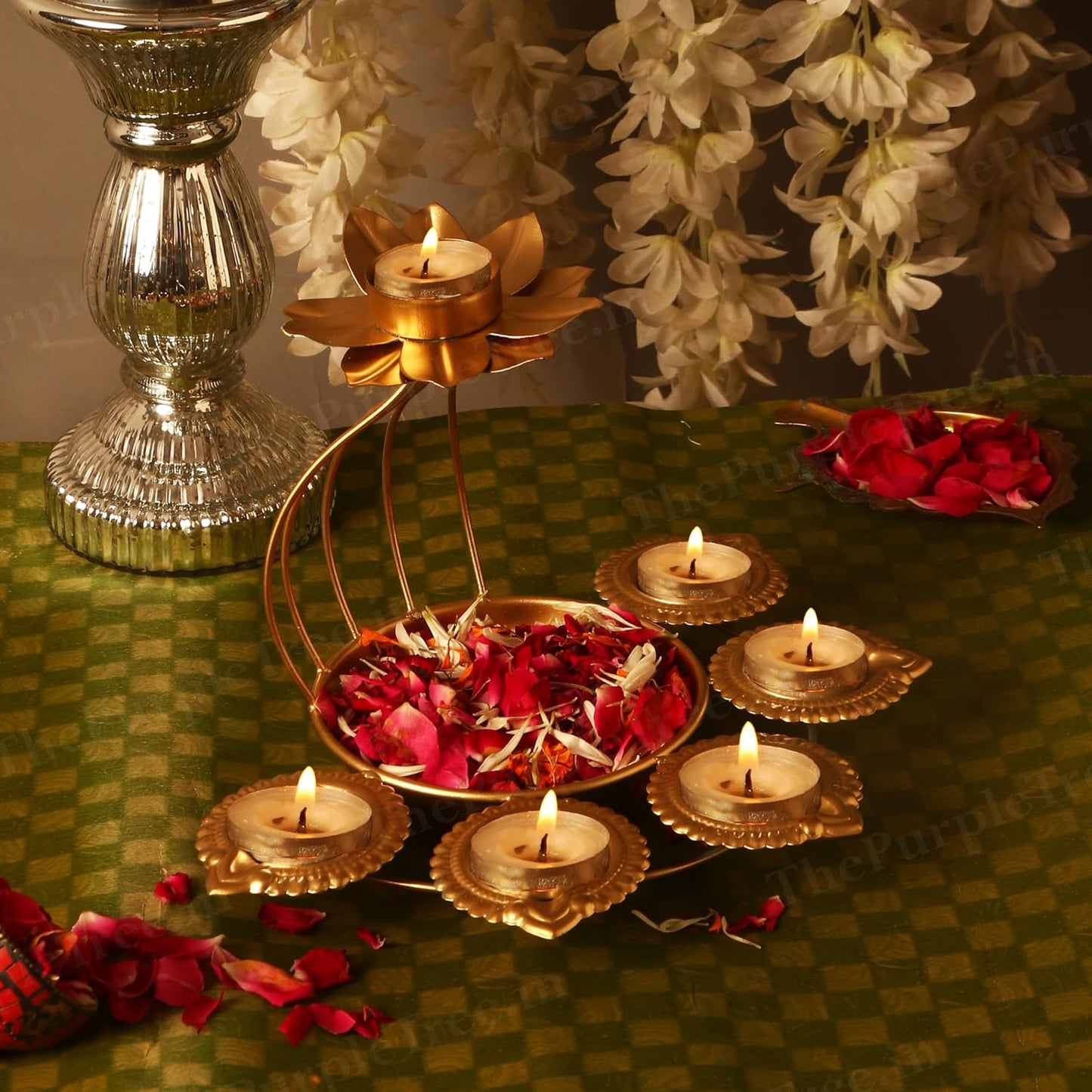 Decorative gold candle holder with flowers and candles on a table.