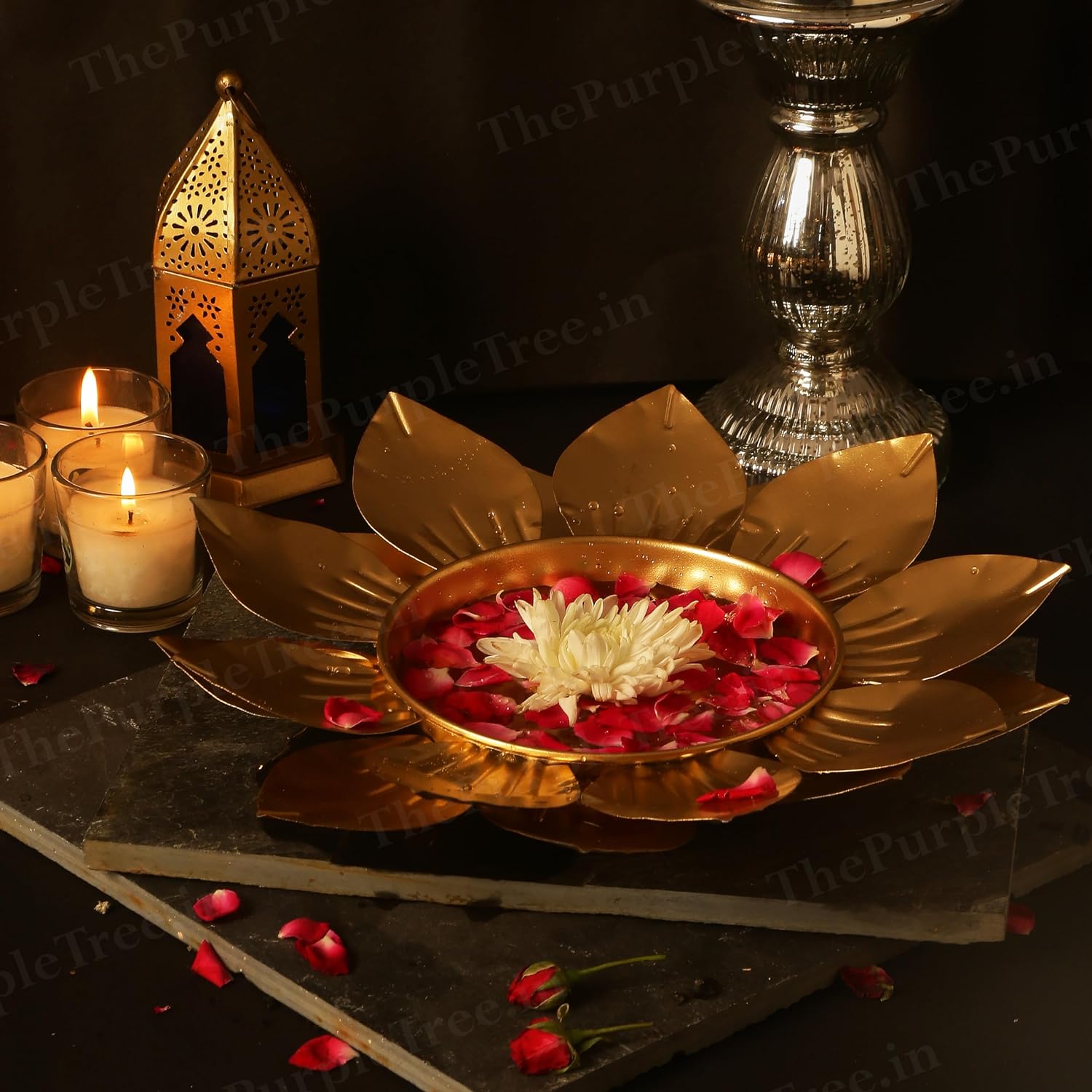 Golden flower-shaped diya with lit candles, symbolizing light and positivity during festive celebrations.