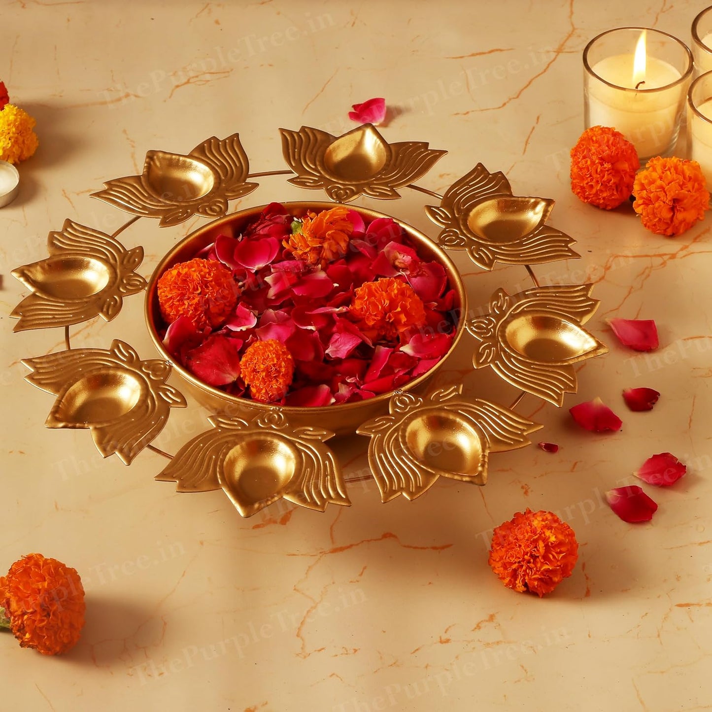 Gold plated diya adorned with vibrant flowers and flickering candles, radiating warmth and tranquility.