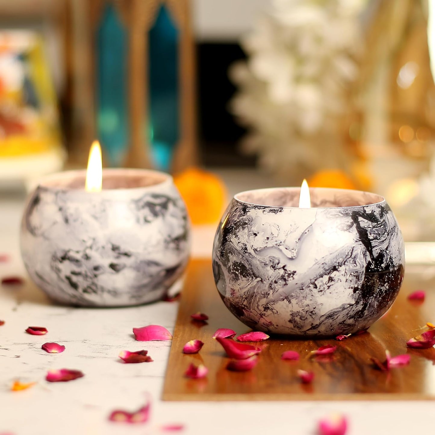 A table set with two candles and a vase of flowers.