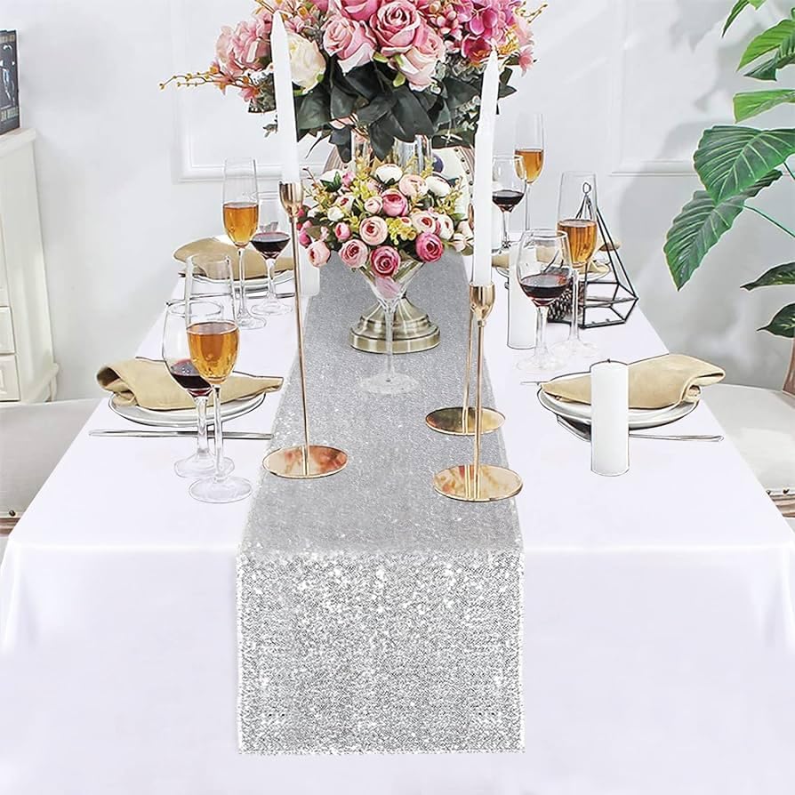 Stylish silver sequin table runner complemented by pretty flowers.