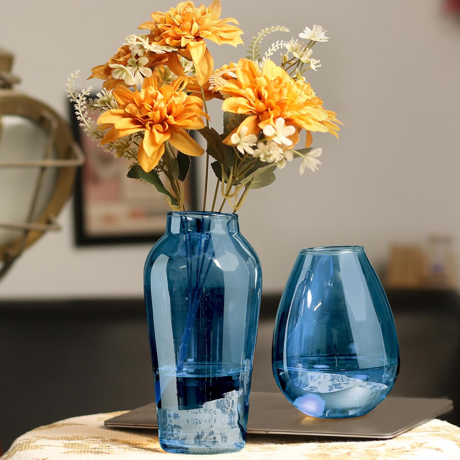 A blue vase with yellow flowers beautifully arranged on a table, adding a touch of color and elegance.