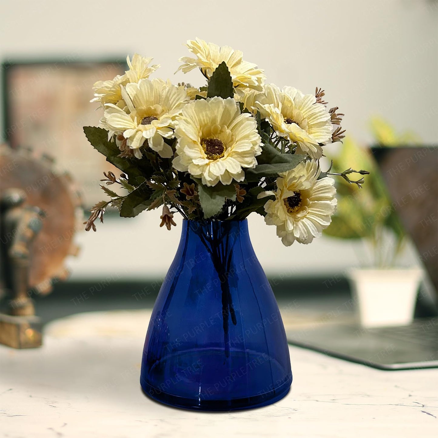 A blue vase filled with a variety of colorful flowers, elegantly displayed against a neutral background.