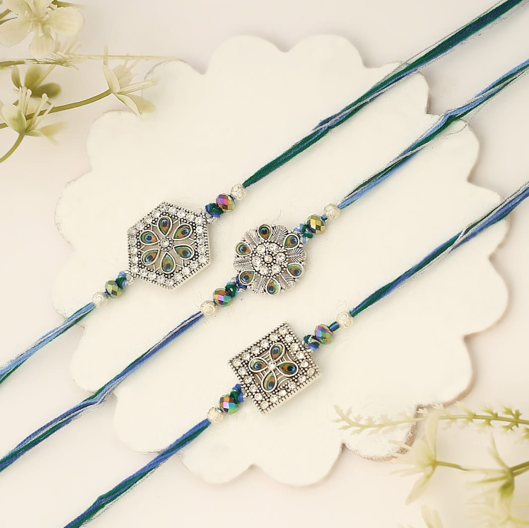 Three blue and green rakhi's with a flower design, perfect for celebrating Raksha Bandhan.